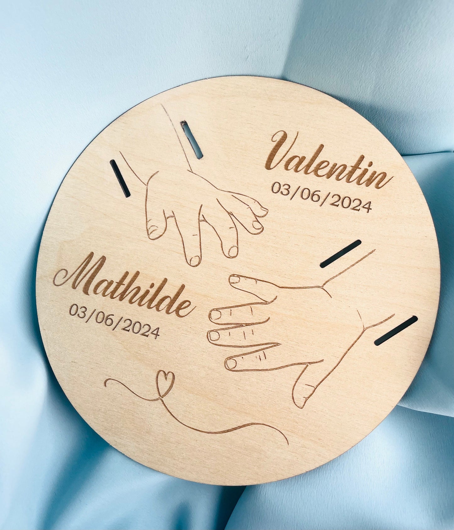 Plaque en bois personnalisée représentant les mains des parents et de l'enfant avec gravure laser.