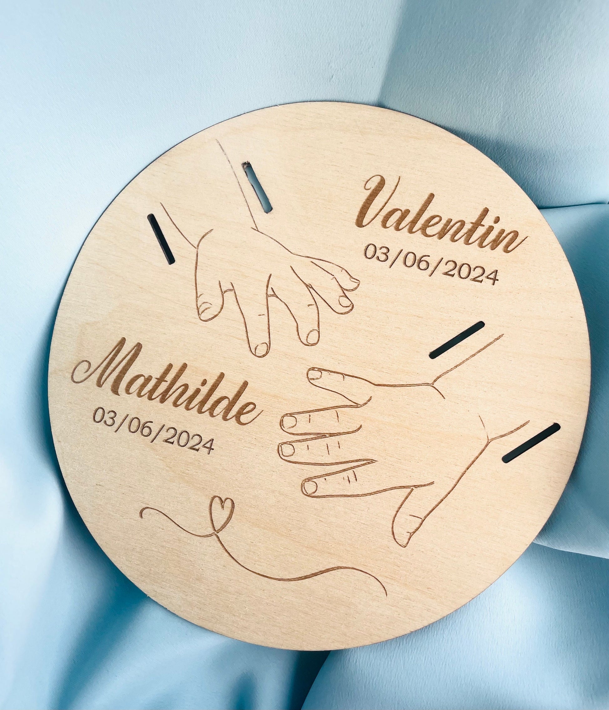 Plaque en bois personnalisée représentant les mains des parents et de l'enfant avec gravure laser.