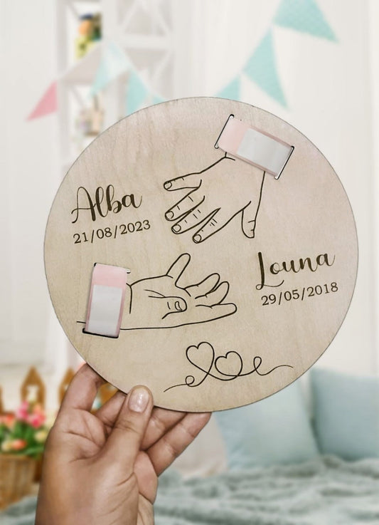 Plaque de naissance personnalisée en bois gravée avec les mains des parents et de l'enfant, prénoms et dates de naissance.