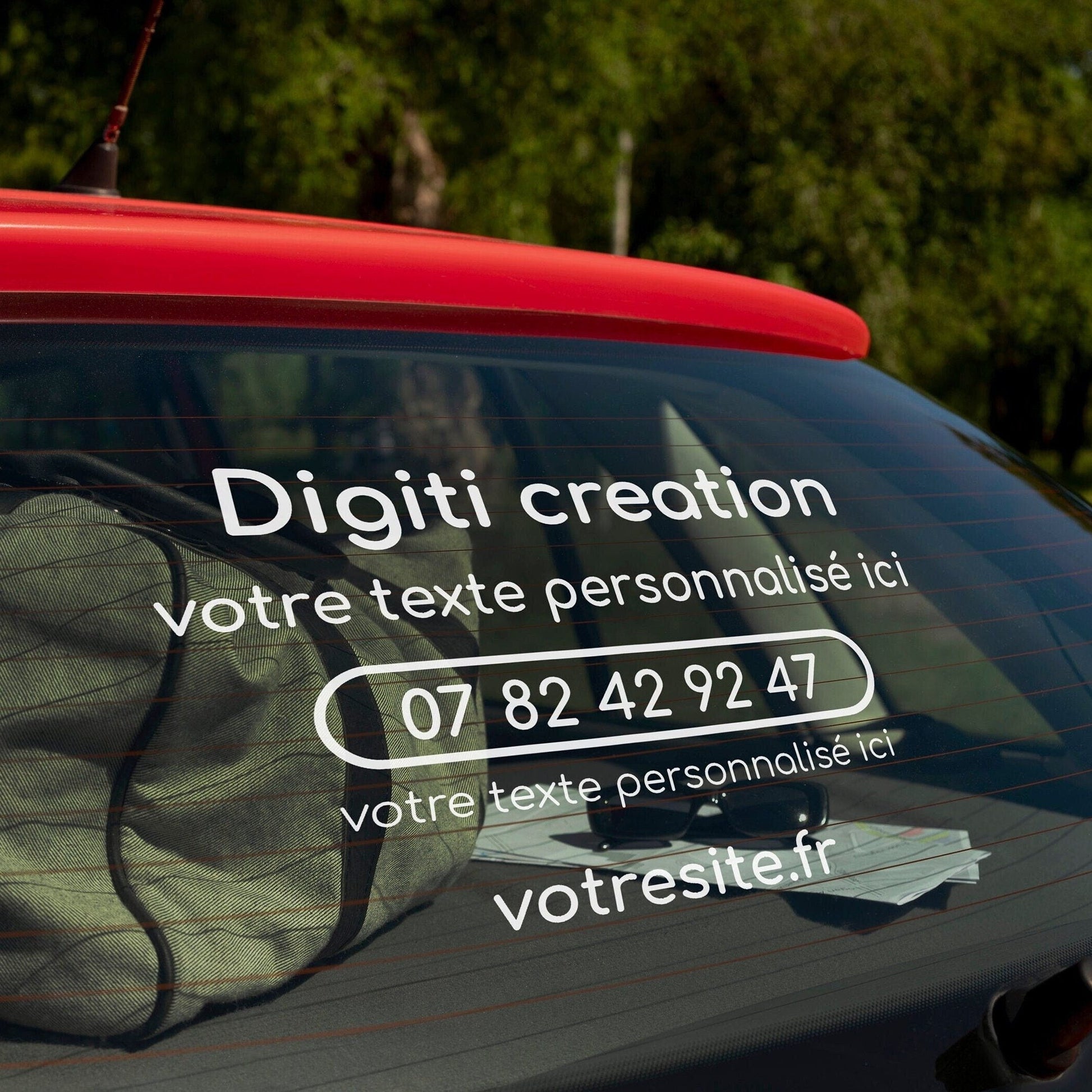 Sticker publicitaire personnalisé pour voiture avec logo, texte, numéro de téléphone et site web, réalisé par Digiti Création.